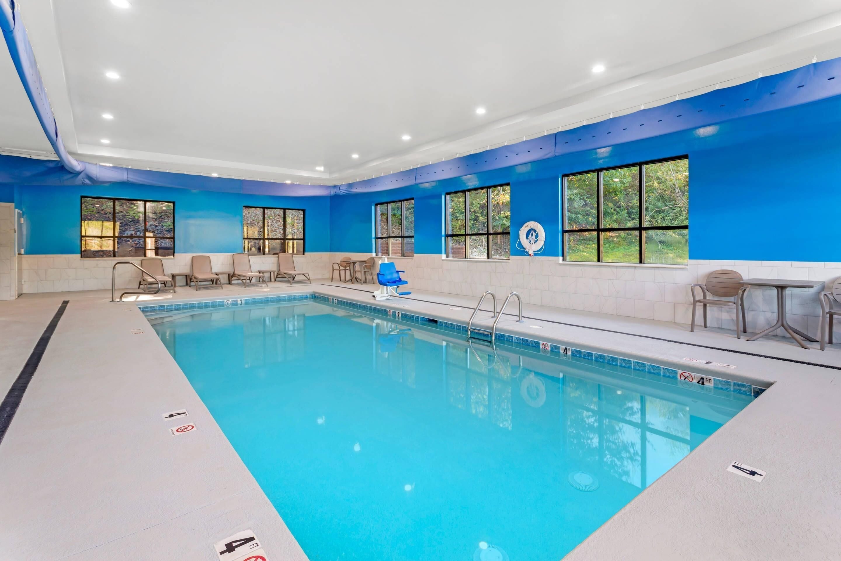 Una piscina techada, sillones reclinables de piscina