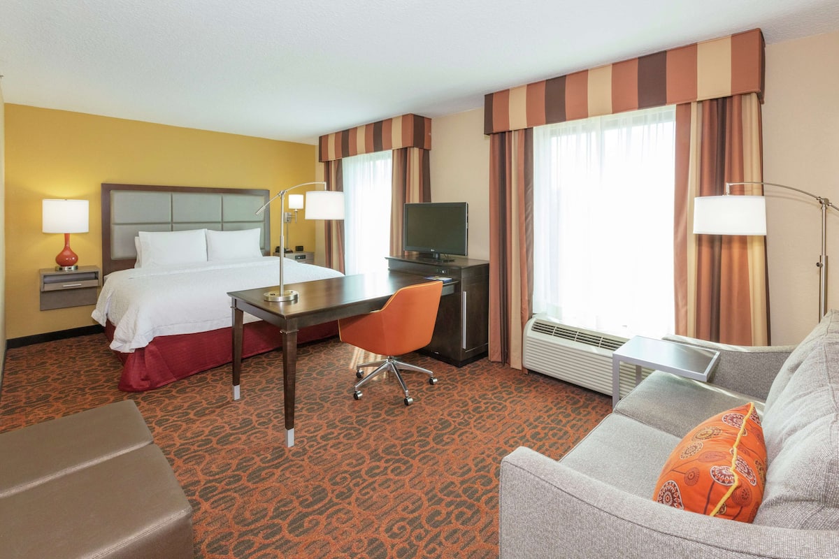 Une chambre d’hôtel équipée d’un lit, d’un bureau, d’une chaise et d’un canapé.