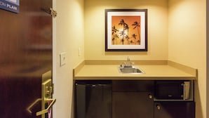 A compact kitchen with a sink, a dishwasher, and a microwave.