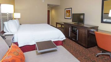 A hotel room with a bed, a desk, a television, and a chair.