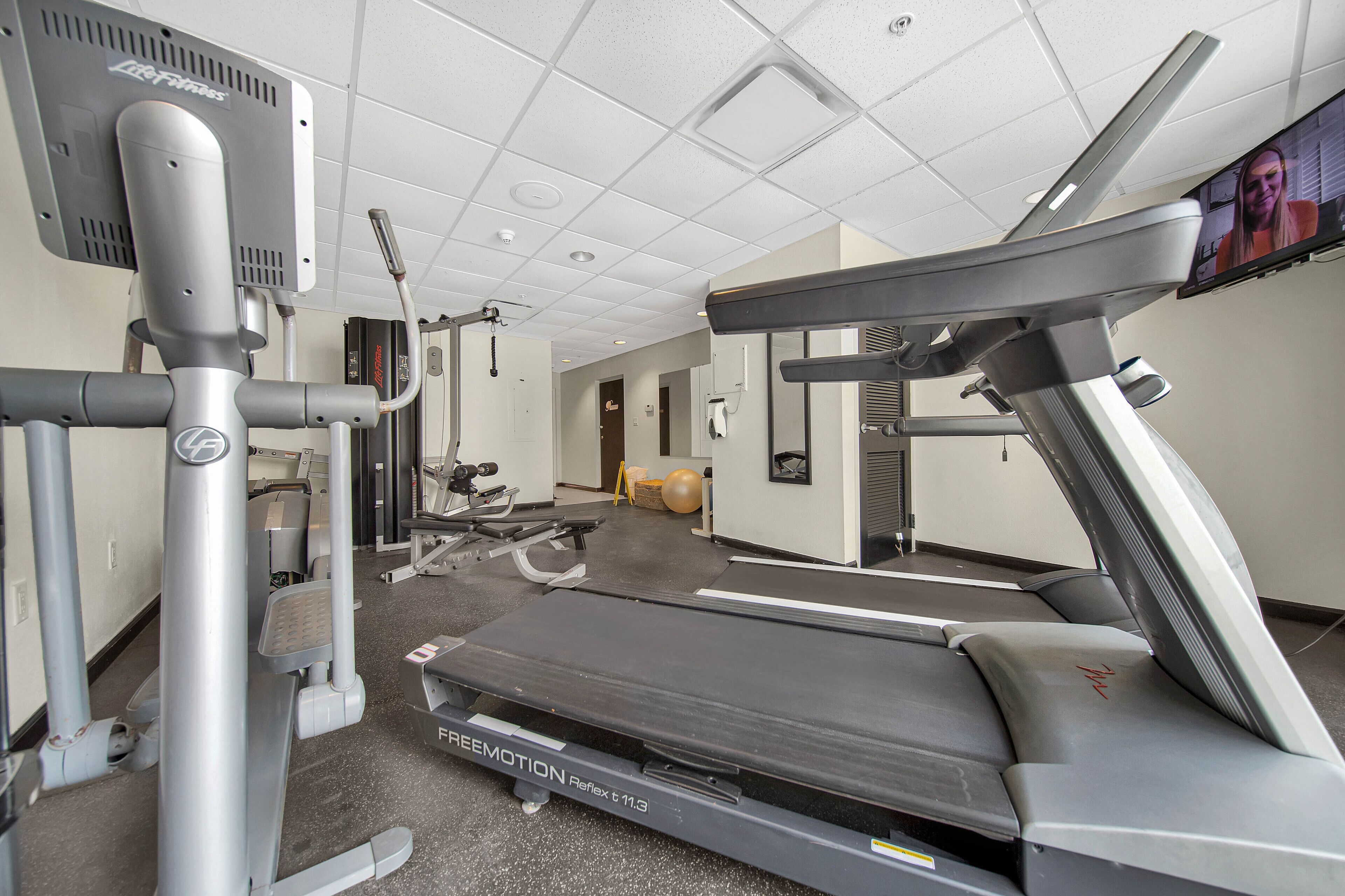A gym with treadmills, weight machines, and a stationary bike.