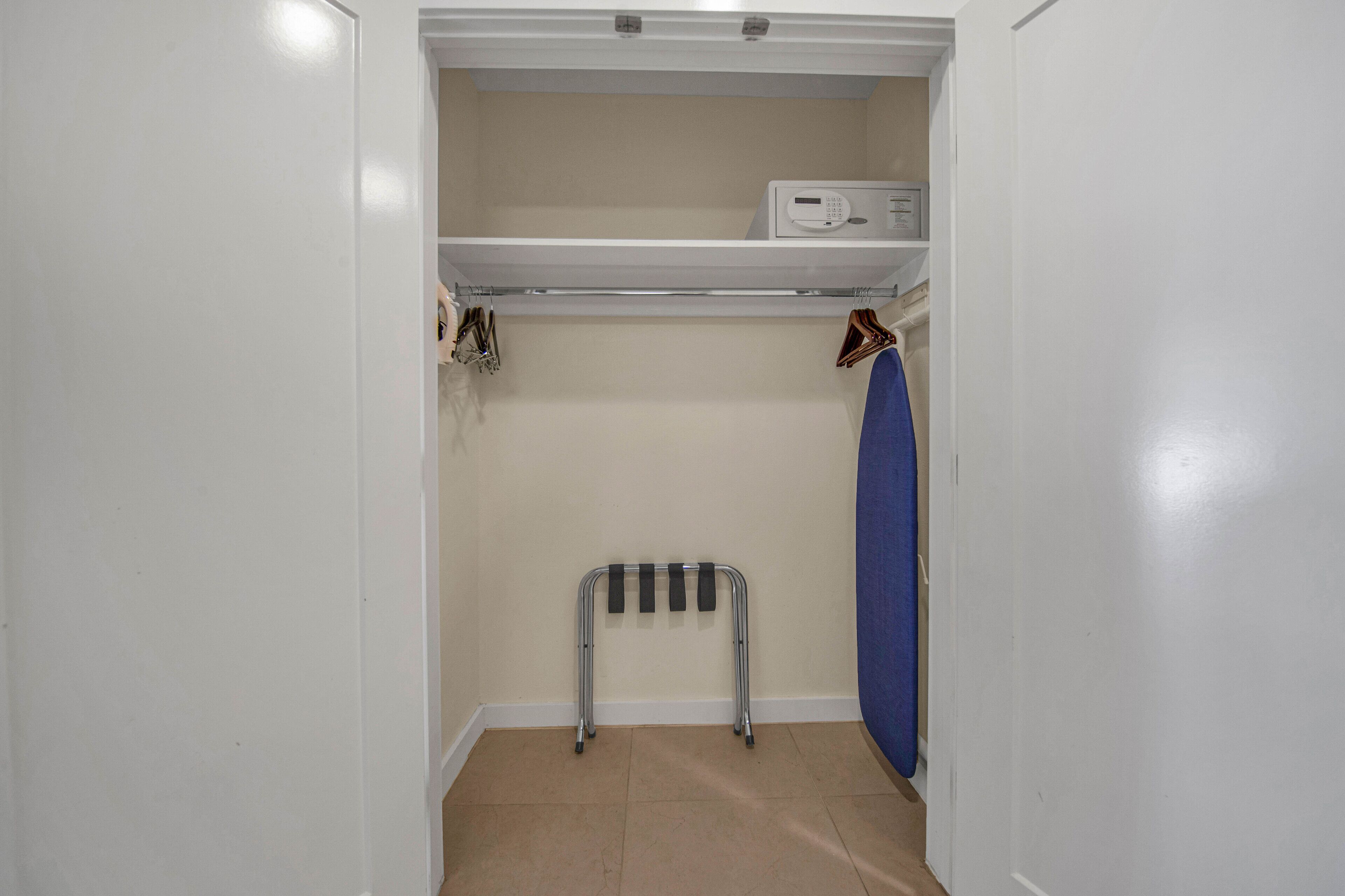 A small, narrow closet with a shelf above and a radiator below.
