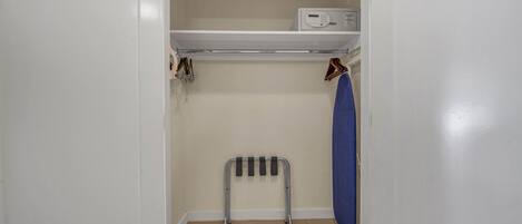 A small, narrow closet with a shelf above and a radiator below.
