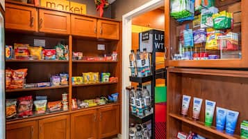 A grocery store with shelves stocked with snacks, beverages, and household items.
