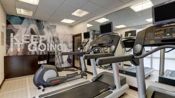 A gym with treadmills, an elliptical, and a stationary bike.