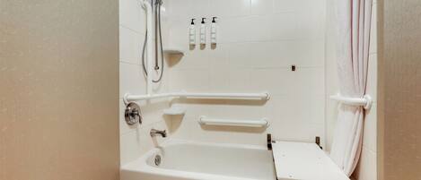 Una bañera blanca con ducha, barras de apoyo y un perchero.