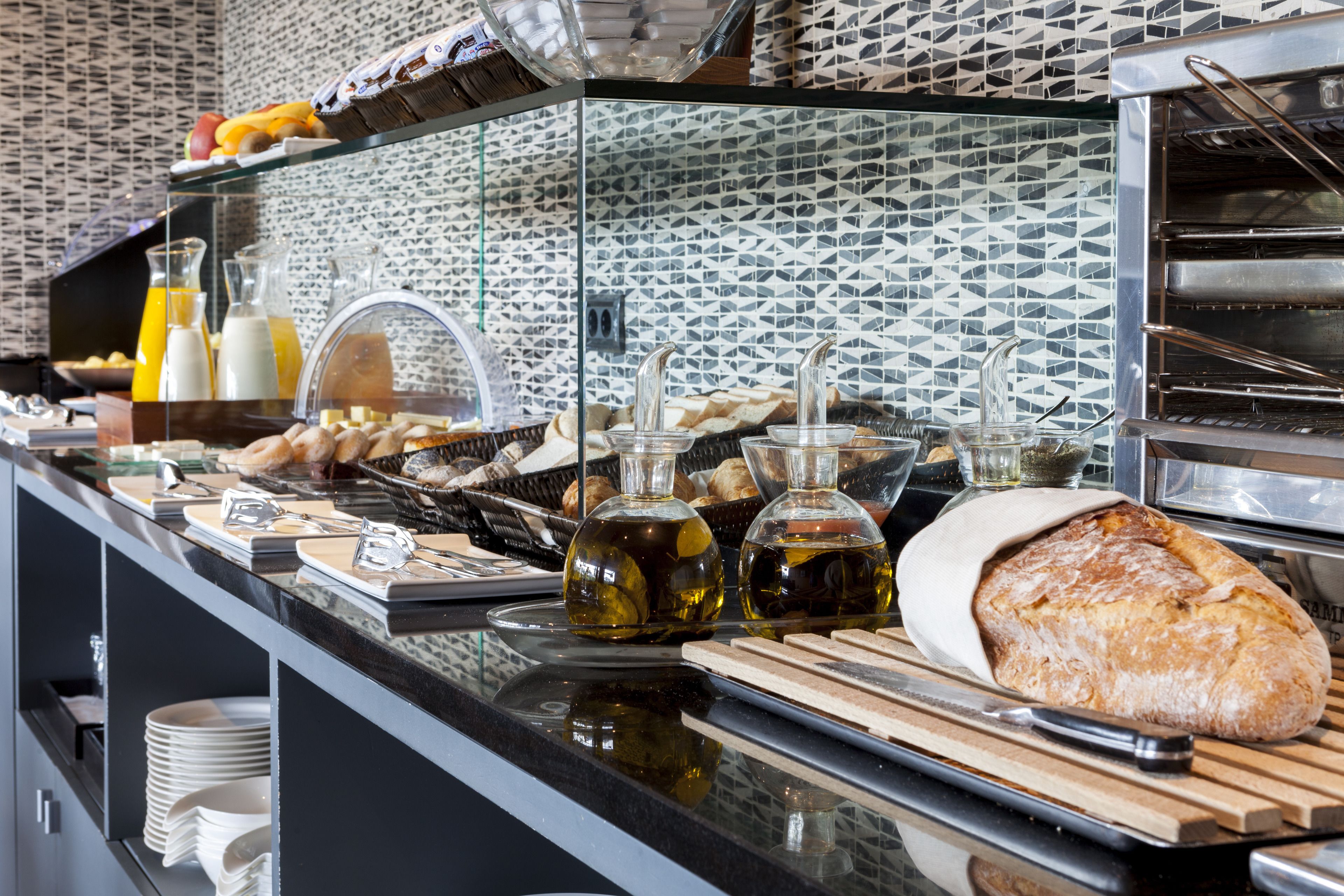 A breakfast buffet with various food items, including bread, pastries, and condiments.