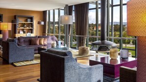 A modern living room with a large window, a fireplace, and a seating area with sofas and a coffee table.