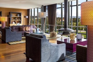A modern living room with a large window, a fireplace, and a seating area with sofas and a coffee table.