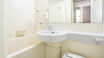 A bathroom with a bathtub, a sink, a mirror, and a toilet.