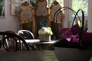 A dining table with a white bowl containing purple orchids. - Villa Nina (Antibes)