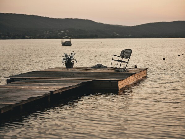 A wooden dock extending into calm water with a chair and a potted plant on it. - Ekies All Senses Resort, a Member of Design Hotels (Sithonia)