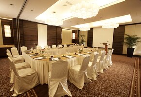 A conference room with a long table, chairs, and a podium.