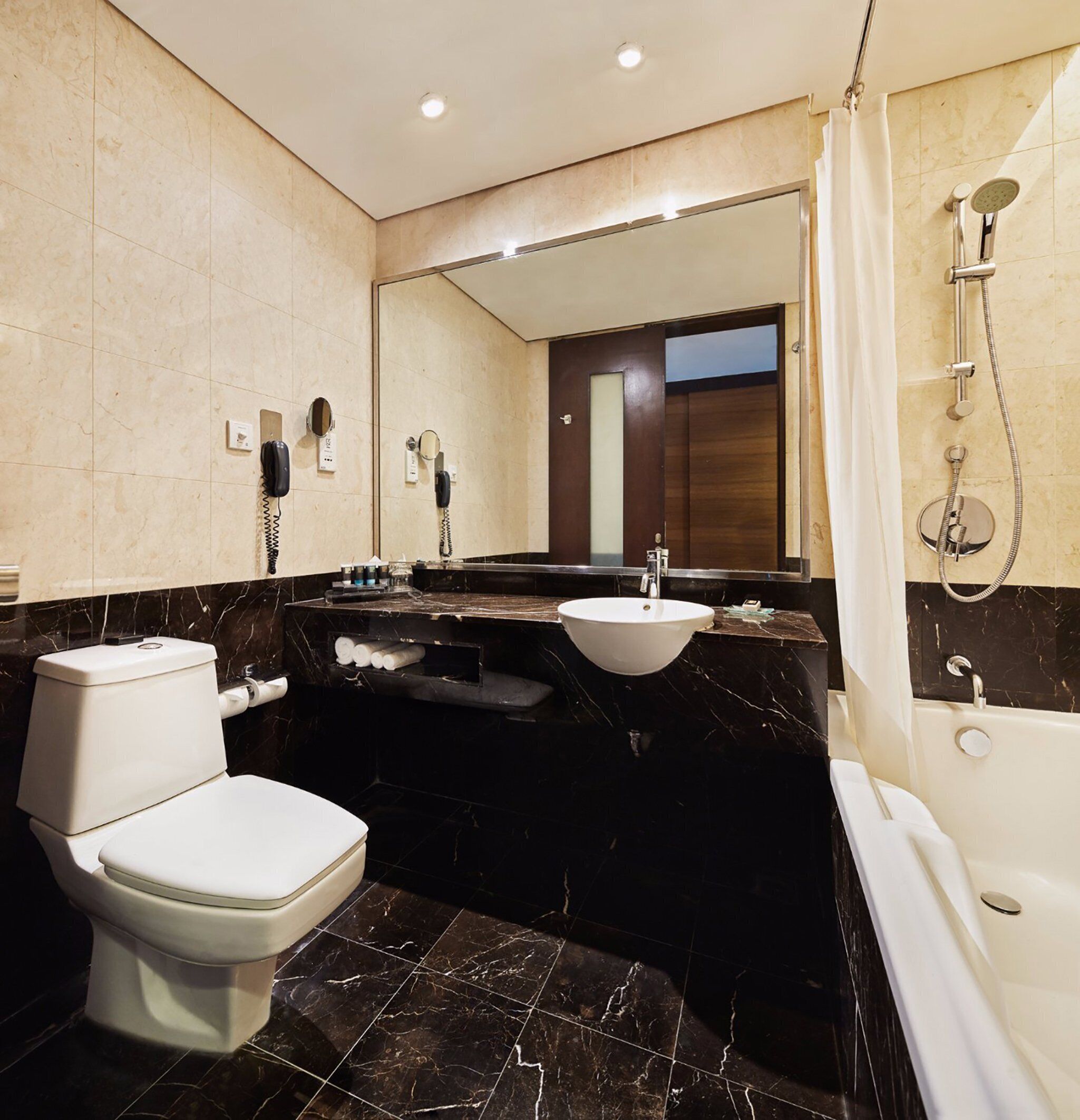 A modern bathroom with a toilet, sink, and bathtub.