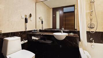 A modern bathroom with a toilet, sink, and bathtub.