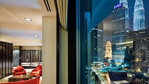 Un interior de hotel moderno con vistas a las Torres Petronas de noche.