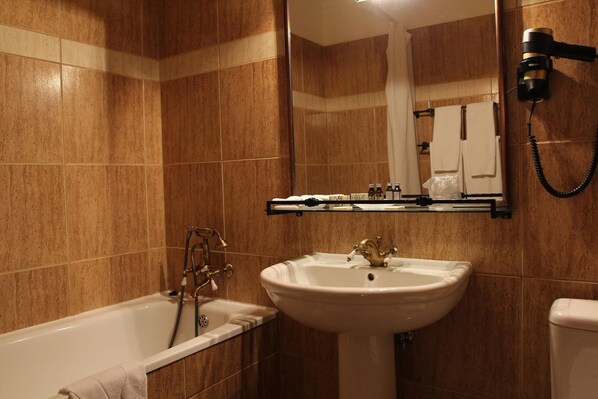 A bathroom with a bathtub, a sink, and a mirror.