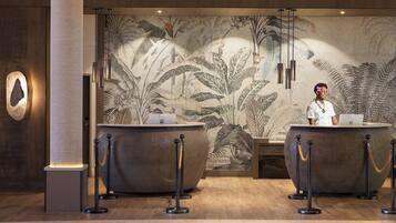 A reception area with two counters, a large decorative wall, and a column.