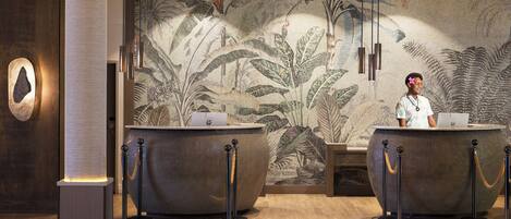 A reception area with two counters, a large decorative wall, and a column.