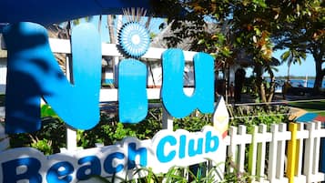 Une enseigne indiquant l’entrée d’un club de plage, avec l’inscription « Viu Beach Club ».