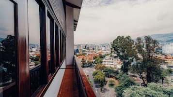 Un balcón con vistas a un paisaje urbano, con edificios y árboles.