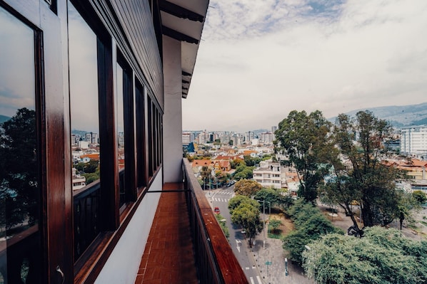 Un balcón con vistas a un paisaje urbano, con edificios y árboles.