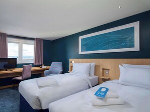 A hotel room with two beds, a desk with a chair, a television, and a large window with curtains. - Travelodge Croydon Central (Croydon)