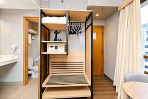 A bunk bed with a control panel, a drying rack, and a small table in a modern room with a view of a building outside. - Comfort Hotel Joinville (Joinville)