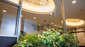 Zona de recepción de un hotel con un cartel que dice "JR-EAST HOTEL METS".