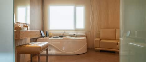 A modern bathroom with a bathtub, a vanity with a mirror, and a window providing natural light.