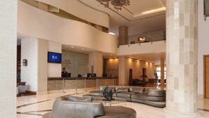 A spacious lobby with a reception desk, seating area, and a staircase leading to an upper level. - Dann Carlton Barranquilla (Barranquilla)