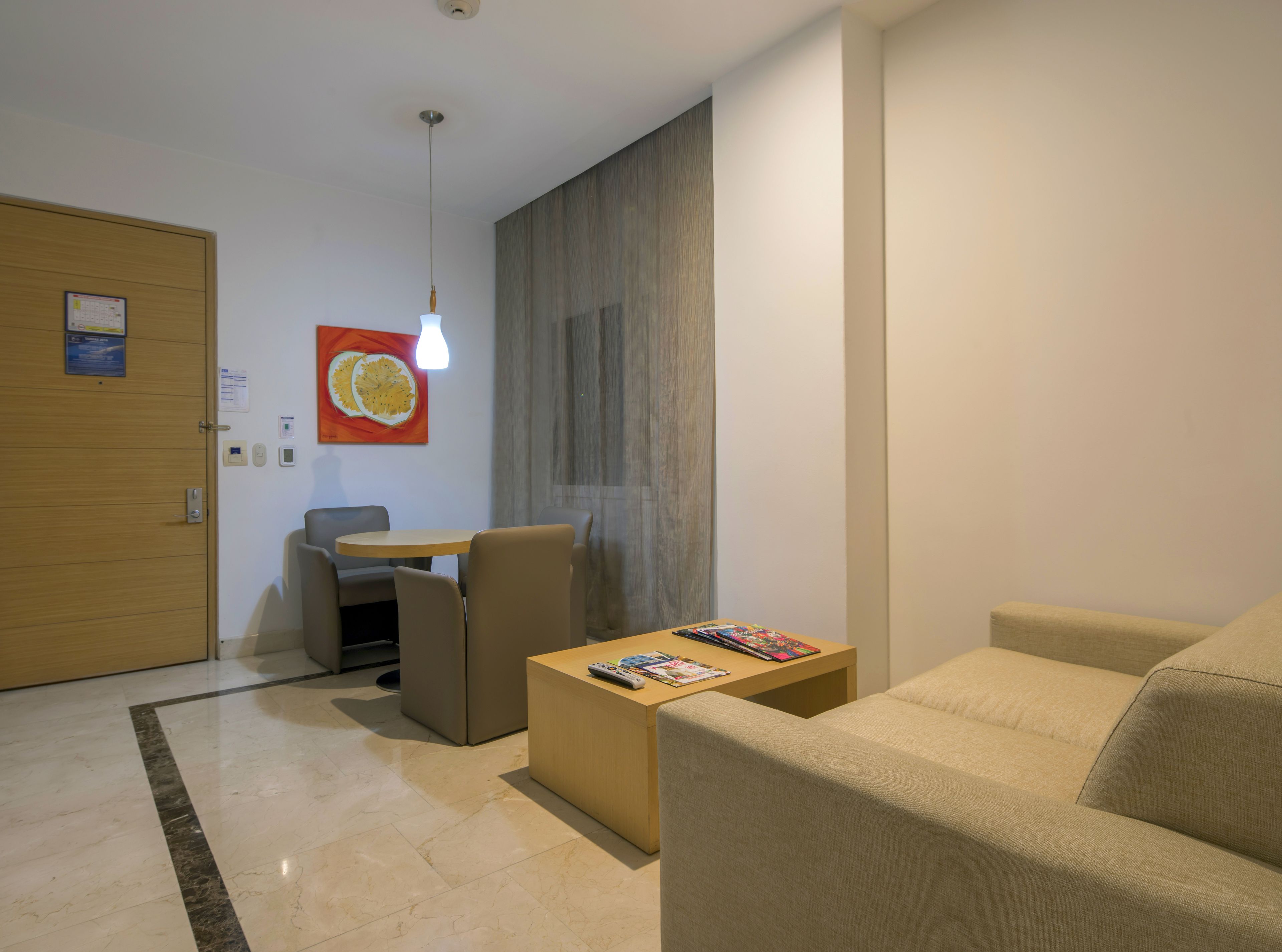 A modern living room with a sofa, a coffee table, and a dining area with a table and chairs.