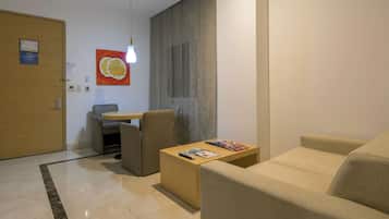 Una sala de estar moderna con un sofá, una mesa de centro y una zona de comedor con una mesa y sillas.