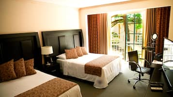 A hotel room with two beds, a desk with a chair, a lamp, and a view of the outdoors.