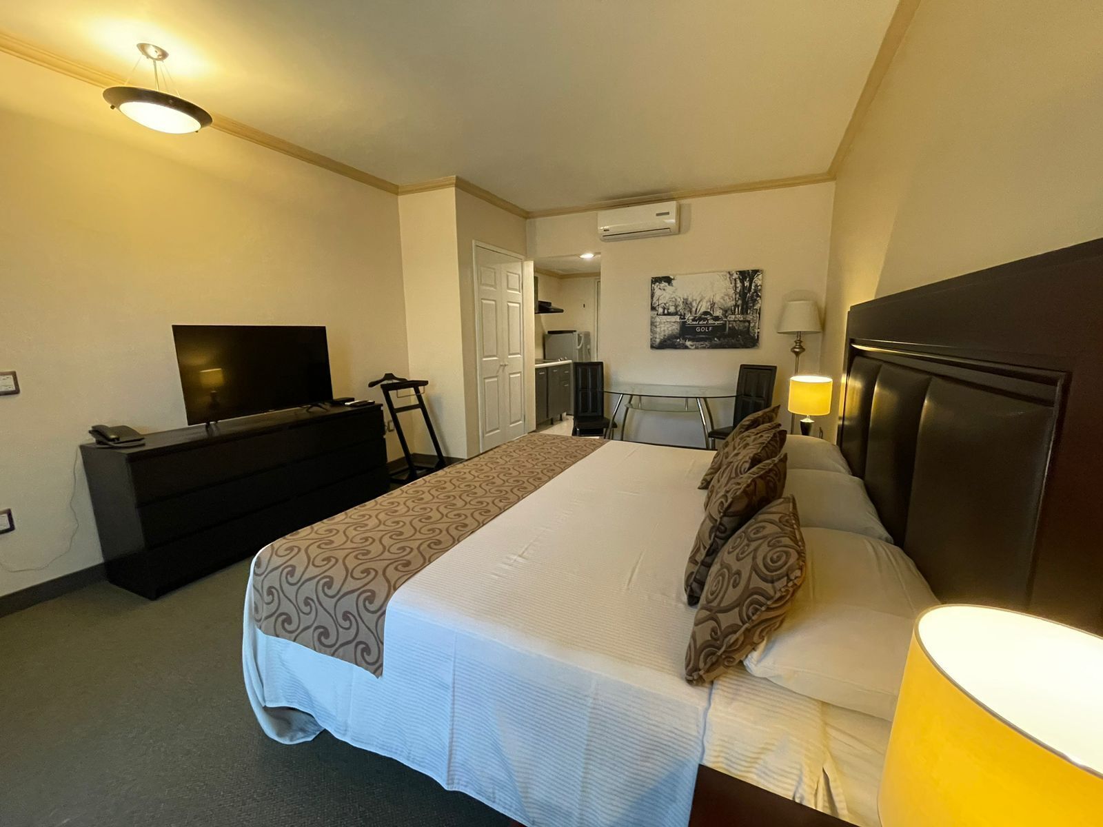 Una habitación de hotel con cama, televisión, escritorio y silla.