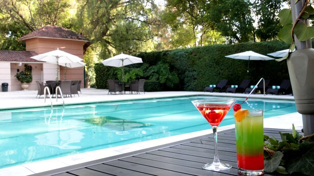 A poolside area with a bar and lounge chairs. - Hotel Real del Bosque Golf and Spa (Tula de Allende)