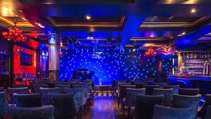 Un bar con filas de sillas y un escenario.
