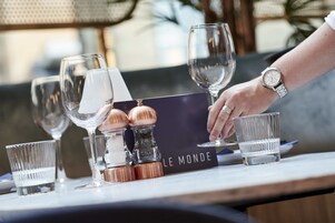 Un bar con varios vasos y una tarjeta de menú que dice "LE MONDE".