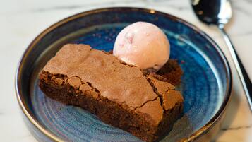 Un postre con una bola de helado en un plato.
