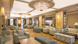 A spacious lobby with multiple seating areas, a grand chandelier, and a modern design. - Terrace Beach Resort - All Inclusive (Manavgat)