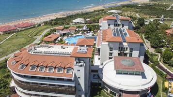 A resort with multiple buildings, a swimming pool, and a beach.