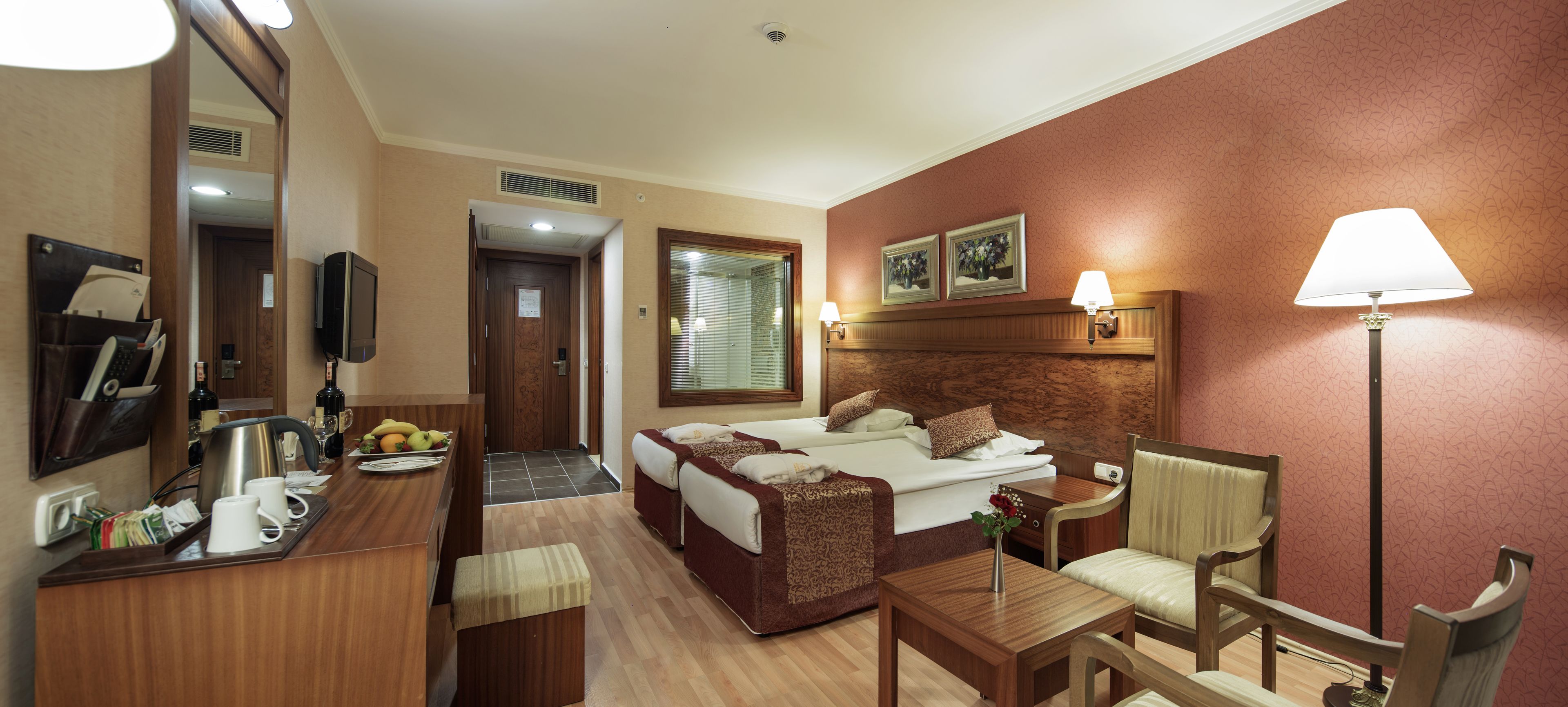 Una habitación de hotel con cama, escritorio, silla y televisor.