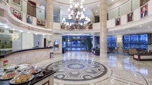 A spacious lobby with a grand chandelier, a reception area, and a buffet with various food items. - Alba Royal Hotel - Ultra All Inclusive - Adults Only 16+ (Manavgat)
