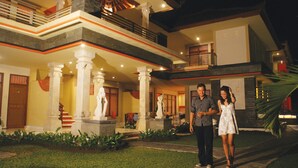 A two-story building with a central courtyard, featuring a statue, a staircase, and a balcony. - Grand Sinar Indah Hotel (Legian)