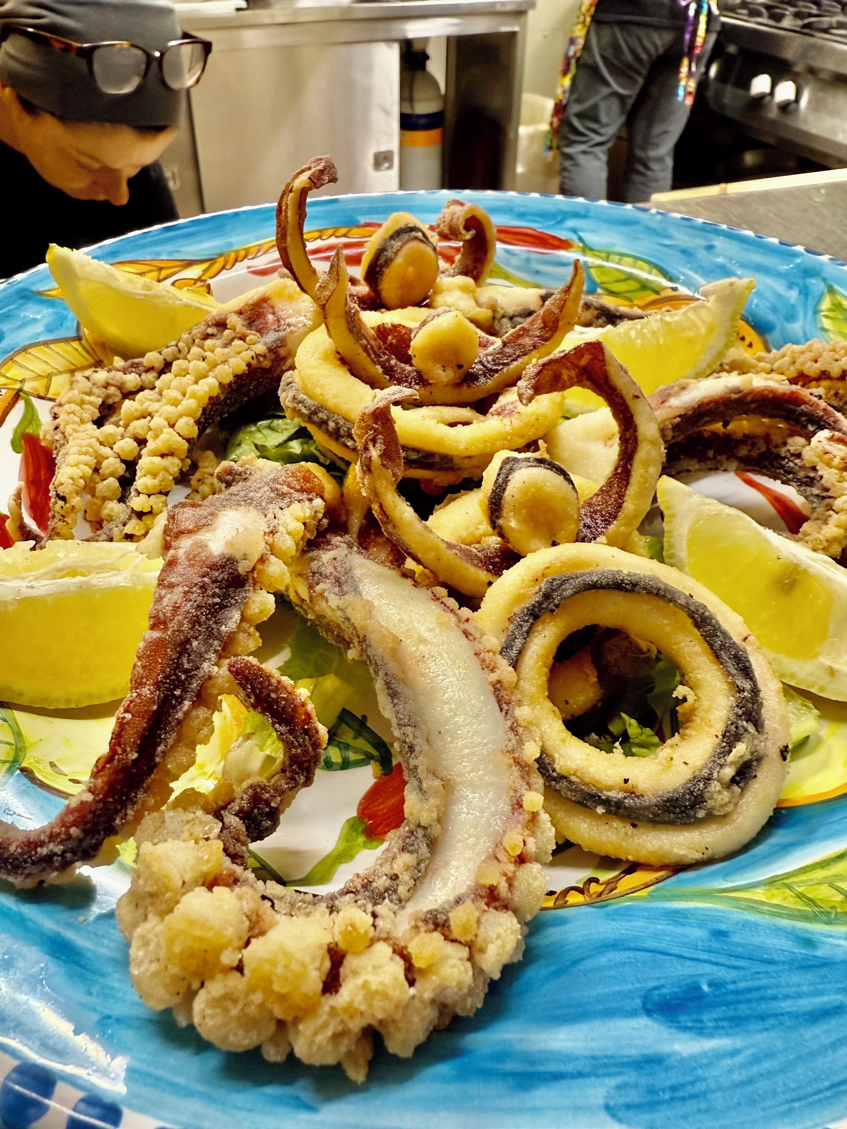 Une assiette de tentacules de poulpe et de tranches de citron.