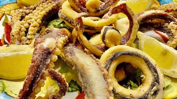 A plate of octopus tentacles and lemon slices.