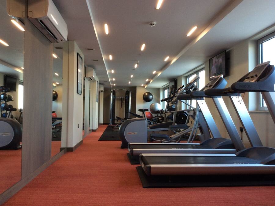A gym with treadmills, exercise balls, and a mirrored wall.
