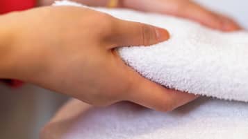 A hand holding a white towel.