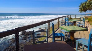 Un restaurant en bord de mer avec une terrasse offrant une vue sur l’océan.