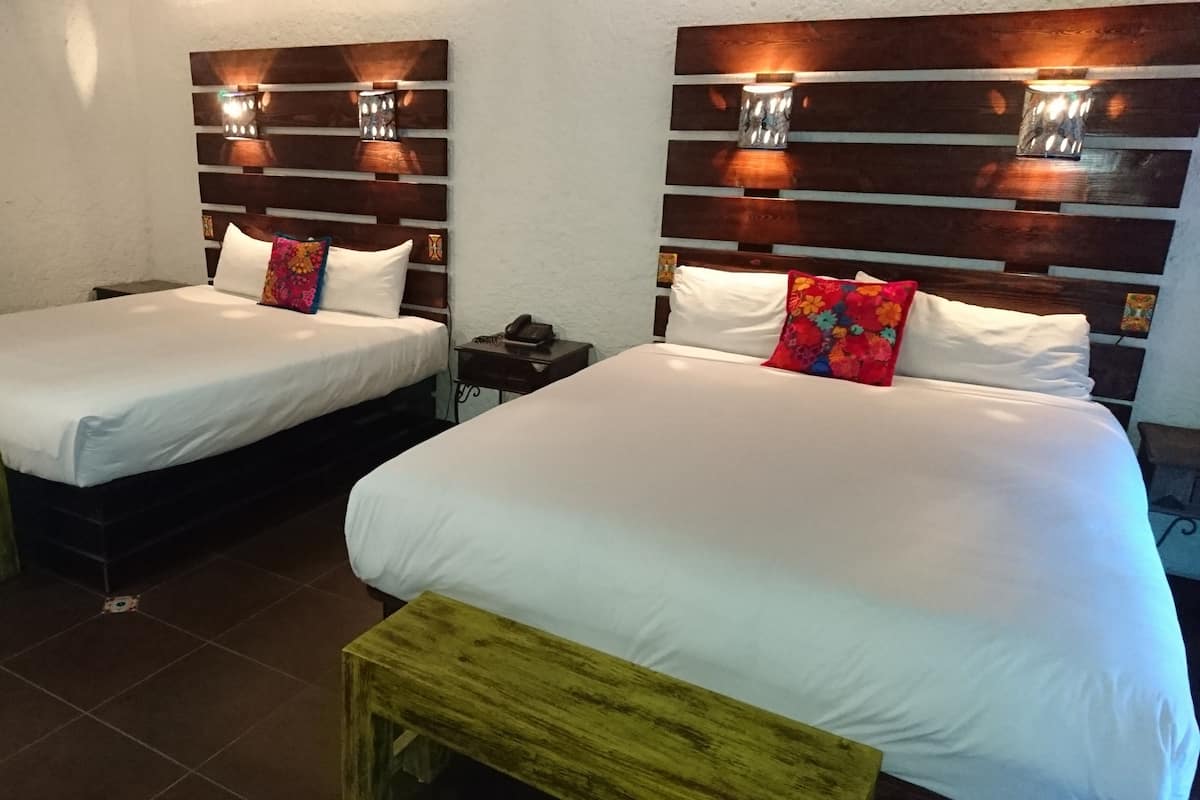 Two single beds with wooden headboards, white bedding, and small bedside tables with lamps.